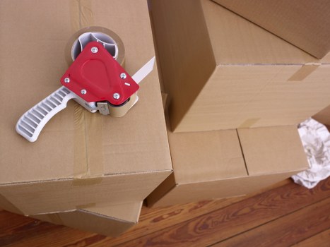 Removalists handling boxes and household items in a Heston property