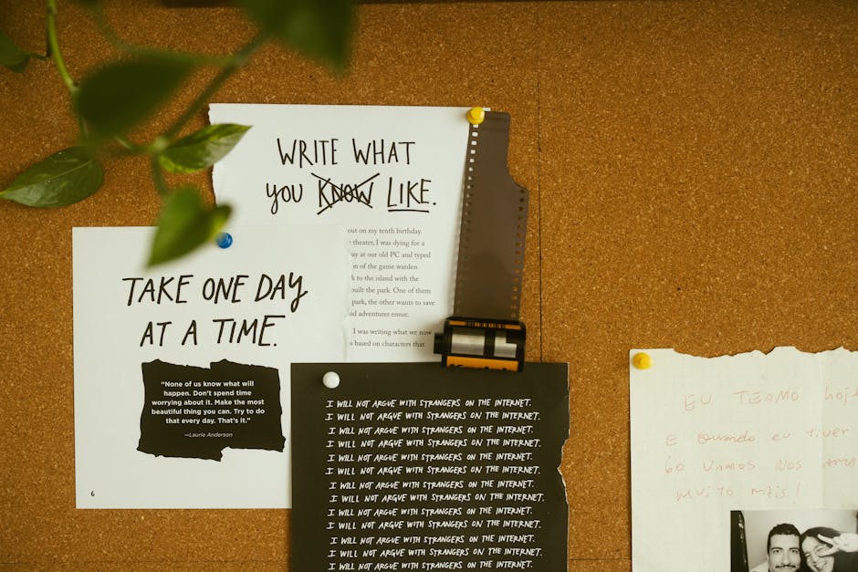 A close-up view of a corkboard mounted on a wall, displaying several pieces of paper with handwritten and printed messages. At the top left, a green plant leaf extends into the frame. The largest paper, positioned centrally, bears the handwritten phrase 'WRITE WHAT YOU KNOW LIKE' with some words crossed out. Below it, a white sheet features the message 'TAKE ONE DAY AT A TIME' with a black quote box underneath that reads, 'None of us know what will happen. Don’t spend time worrying about it. Make the most beautiful thing you can. Try to do that every day. That’s it.' To the right, a torn-edge white paper contains handwritten text in red pencil. In front of these papers, a black and white printed sheet repeats the phrase 'I WILL NOT ARGUE WITH STRANGERS ON THE INTERNET' multiple times. The corkboard is illuminated by warm lighting, with a slightly textured surface, suggesting an indoor setting related to house removals or packing preparations, consistent with the services discussed on manwithvanheston.co.uk.
